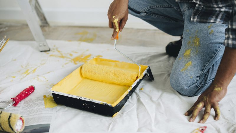 Man painting the walls yellow