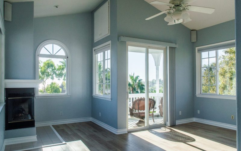 A trendy modern interior of a living room with blue walls and white windows